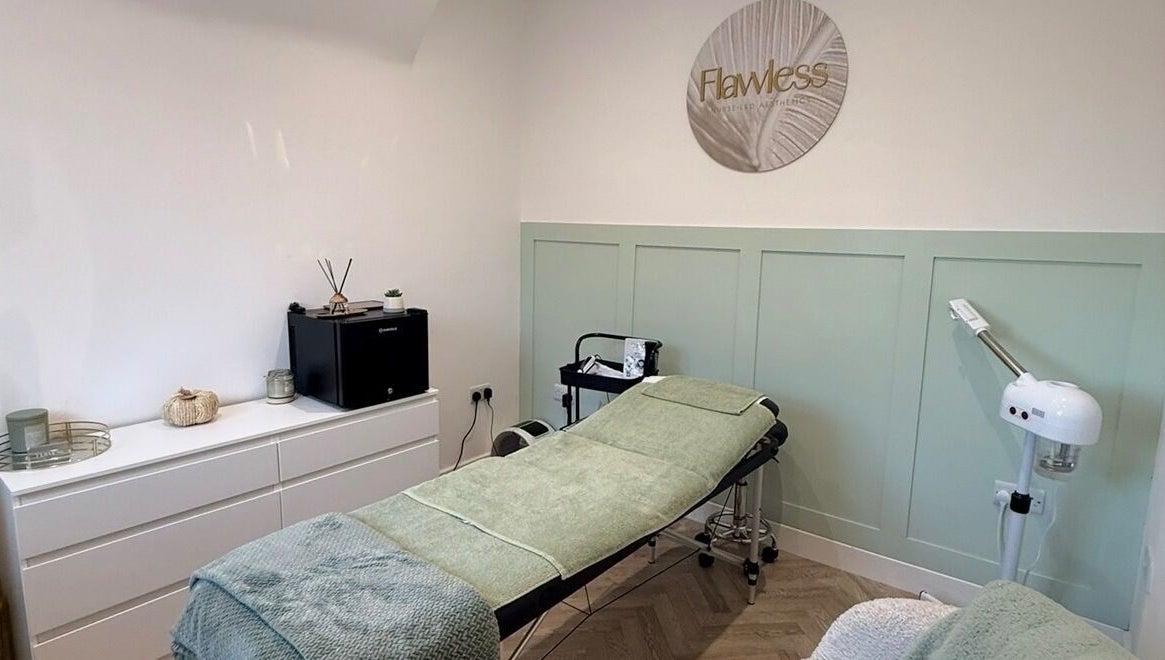 Calming treatment room with spa bed at Flawless in Lostock Hall, England, GB, featuring modern decor.