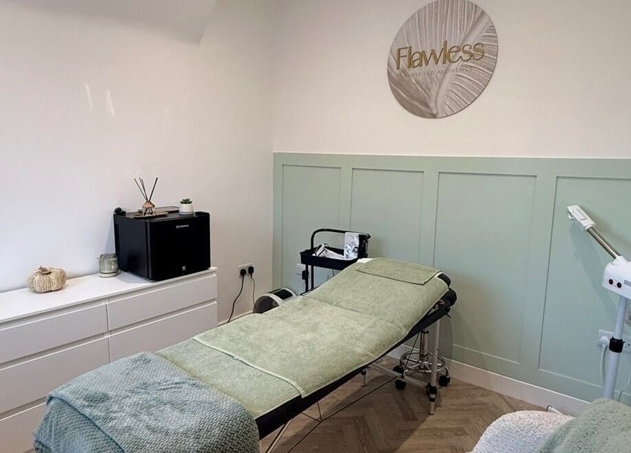 Calming treatment room with spa bed at Flawless in Lostock Hall, England, GB, featuring modern decor.