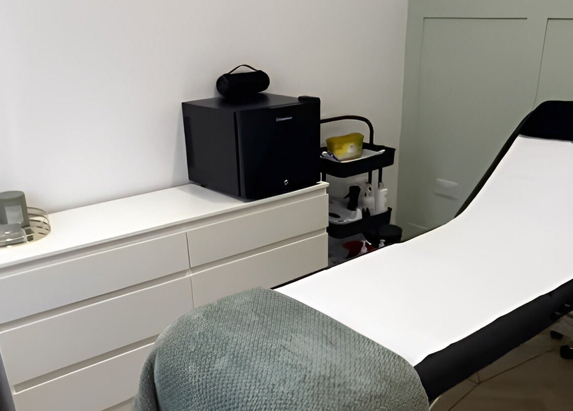 Modern treatment room at Flawless, Lostock Hall, England, GB, featuring a sleek bed and storage unit.