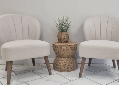 Stylish seating at Brow & Beauty in Mansfield, England, GB. Features two beige chairs and a wicker table with plant.