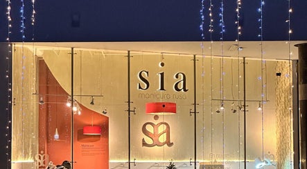 Fachada iluminada de Sia Manicura Rusa en Bogotá, Bogotá, CO, decorada con luces y elegantes detalles en rojo.