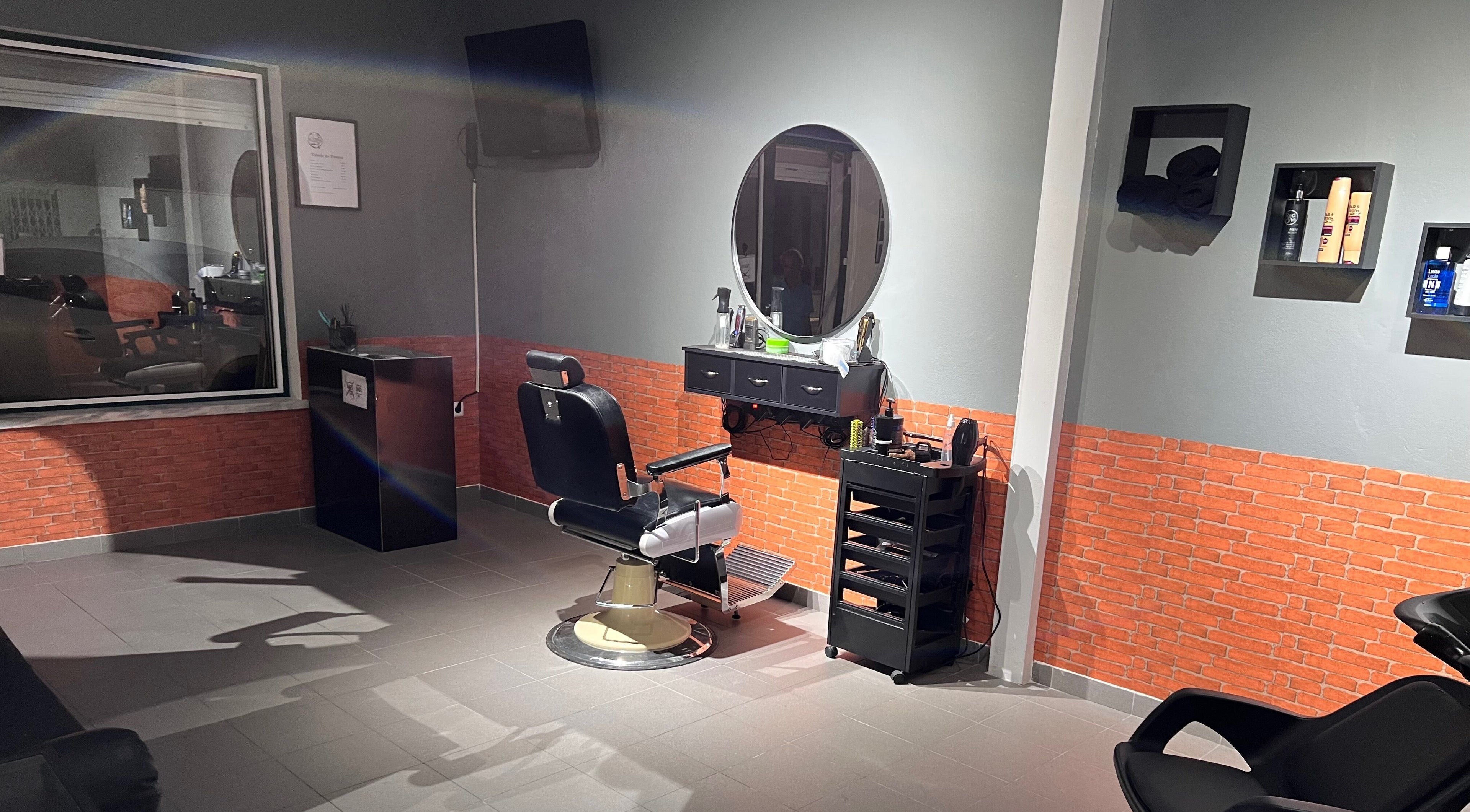 Interior da Silvinho Barbearia em Foros de Salvaterra, Santarém, PT, com cadeira de barbeiro clássica.