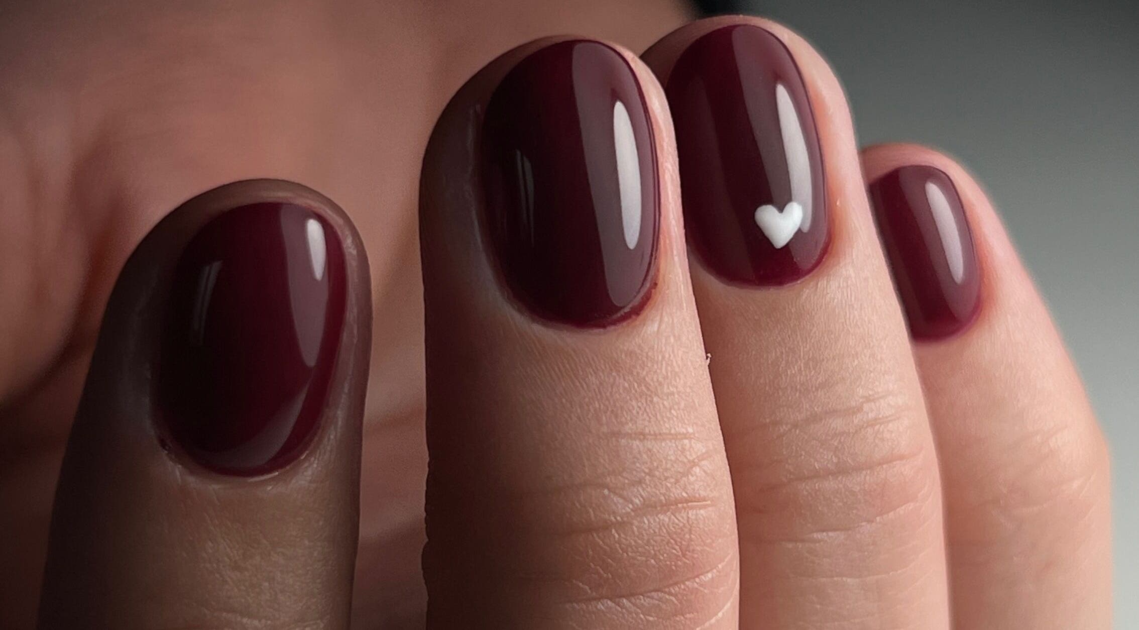 Nail art bordeaux avec cœur blanc chez Beauté Bleu Marine, Gensac-la-Pallue, Nouvelle-Aquitaine, FR.