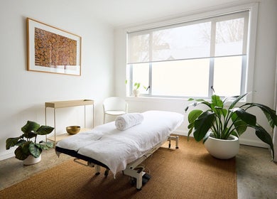 Calming treatment room at The Deep Unwind, Woollahra, New South Wales, AU with a massage table and plants.