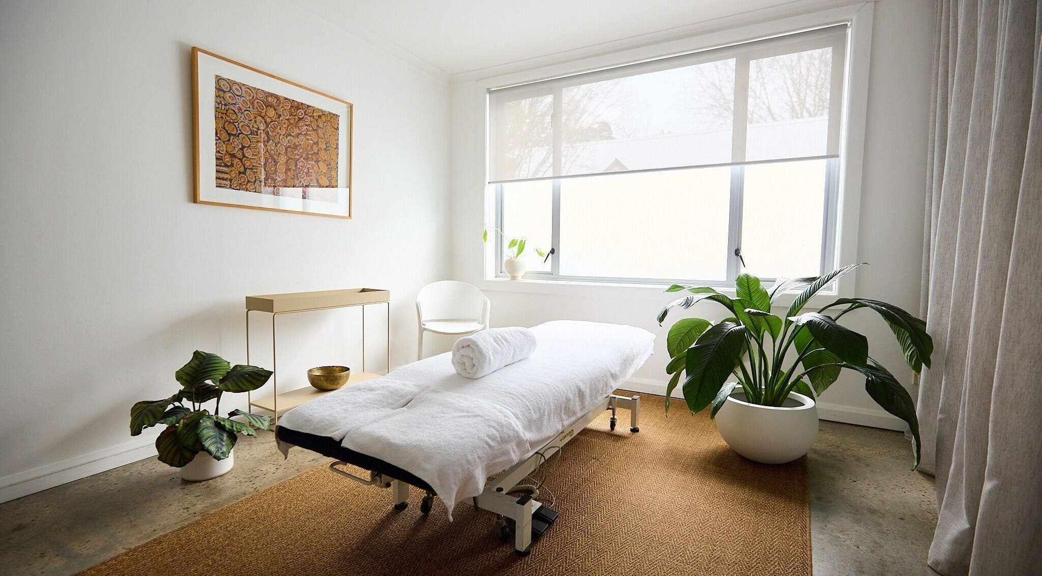 Calming treatment room at The Deep Unwind, Woollahra, New South Wales, AU with a massage table and plants.