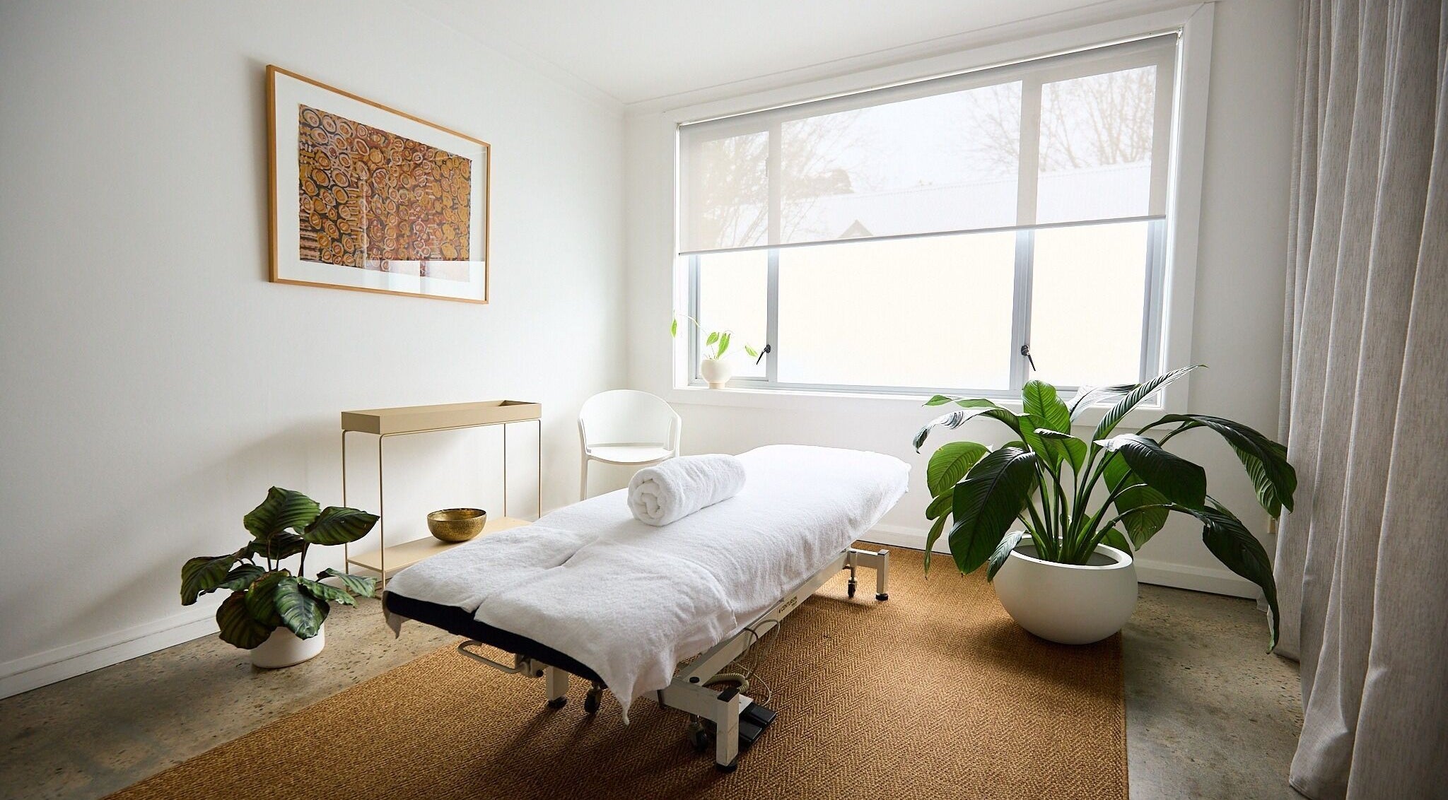 Calming treatment room at The Deep Unwind, Woollahra, New South Wales, AU with a massage table and plants.