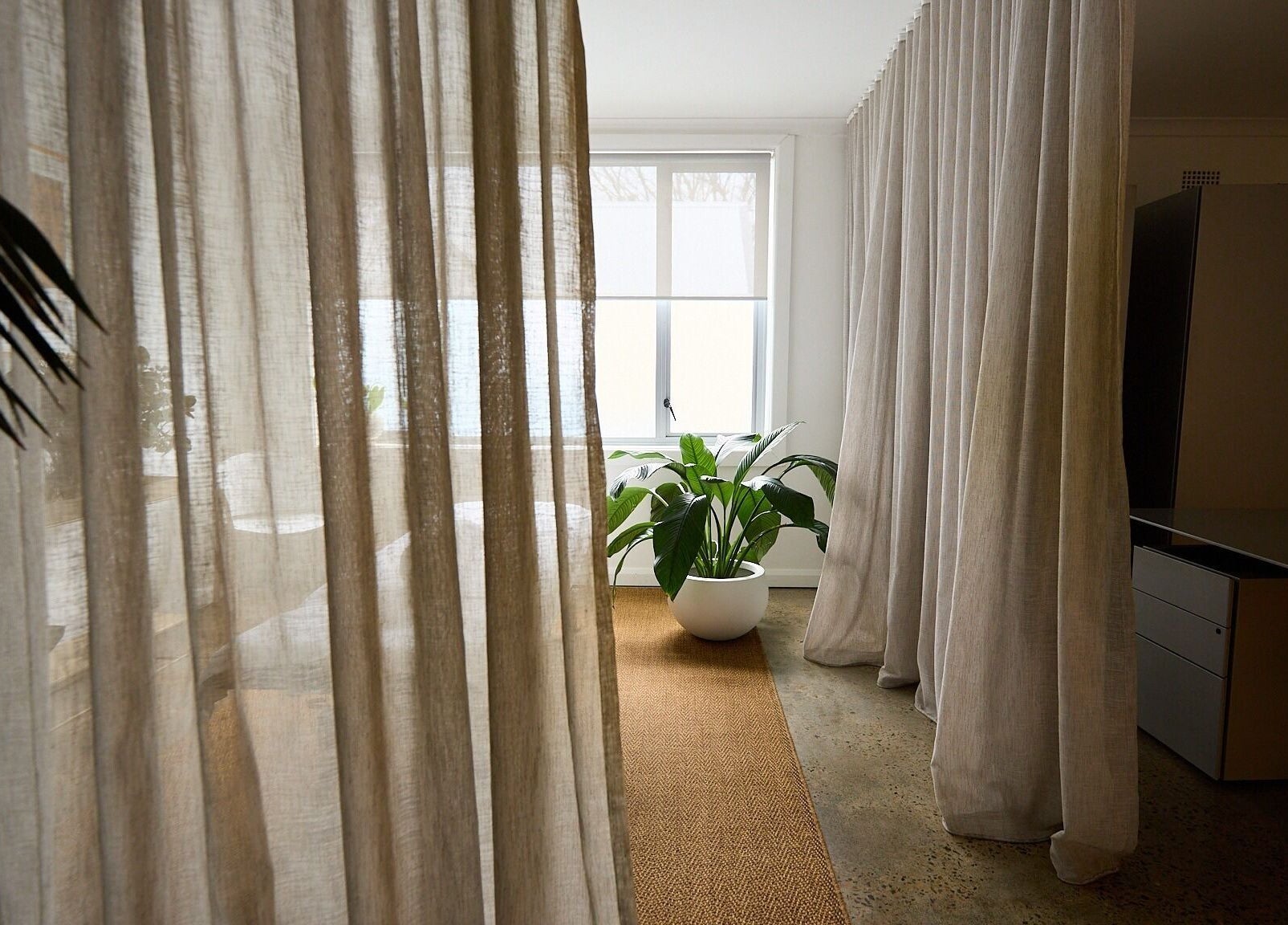Tranquil spa setting at The Deep Unwind, Woollahra, New South Wales, AU with soft curtains and lush plant.