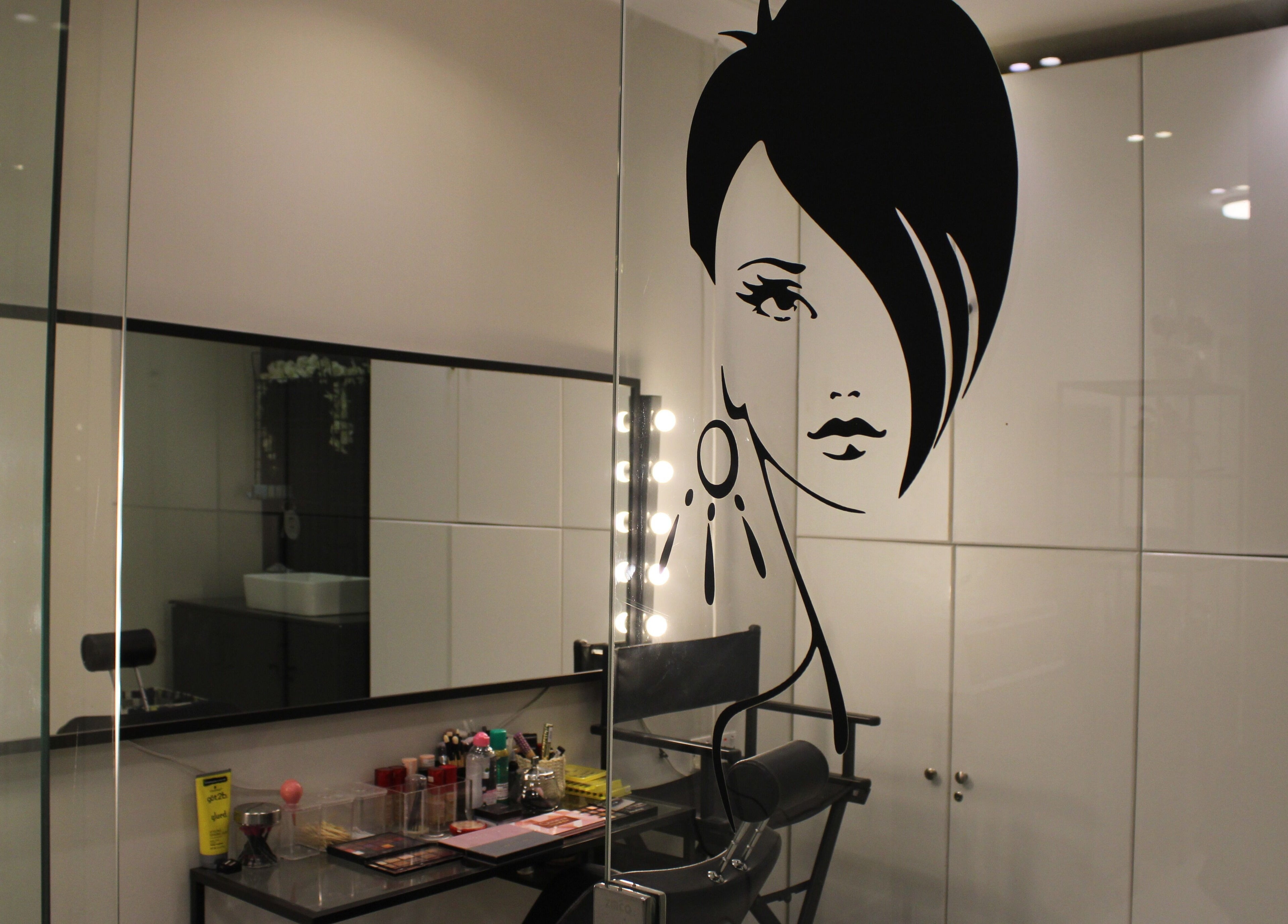 Elegant makeup station at Aklel AlJamal Salon, Riyadh, Riyadh Province, SA, with artistic wall design.