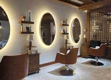 Chic interior of Noor Alhala Beauty Salon in الشارقة, إمارة الشارقةّ, AE with stylish illuminated mirrors.