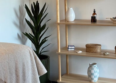 Cozy corner at By Naums, Tauranga, Bay Of Plenty Region, NZ. Features a plant, shelves, and soothing decor.