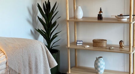 Cozy corner at By Naums, Tauranga, Bay Of Plenty Region, NZ. Features a plant, shelves, and soothing decor.