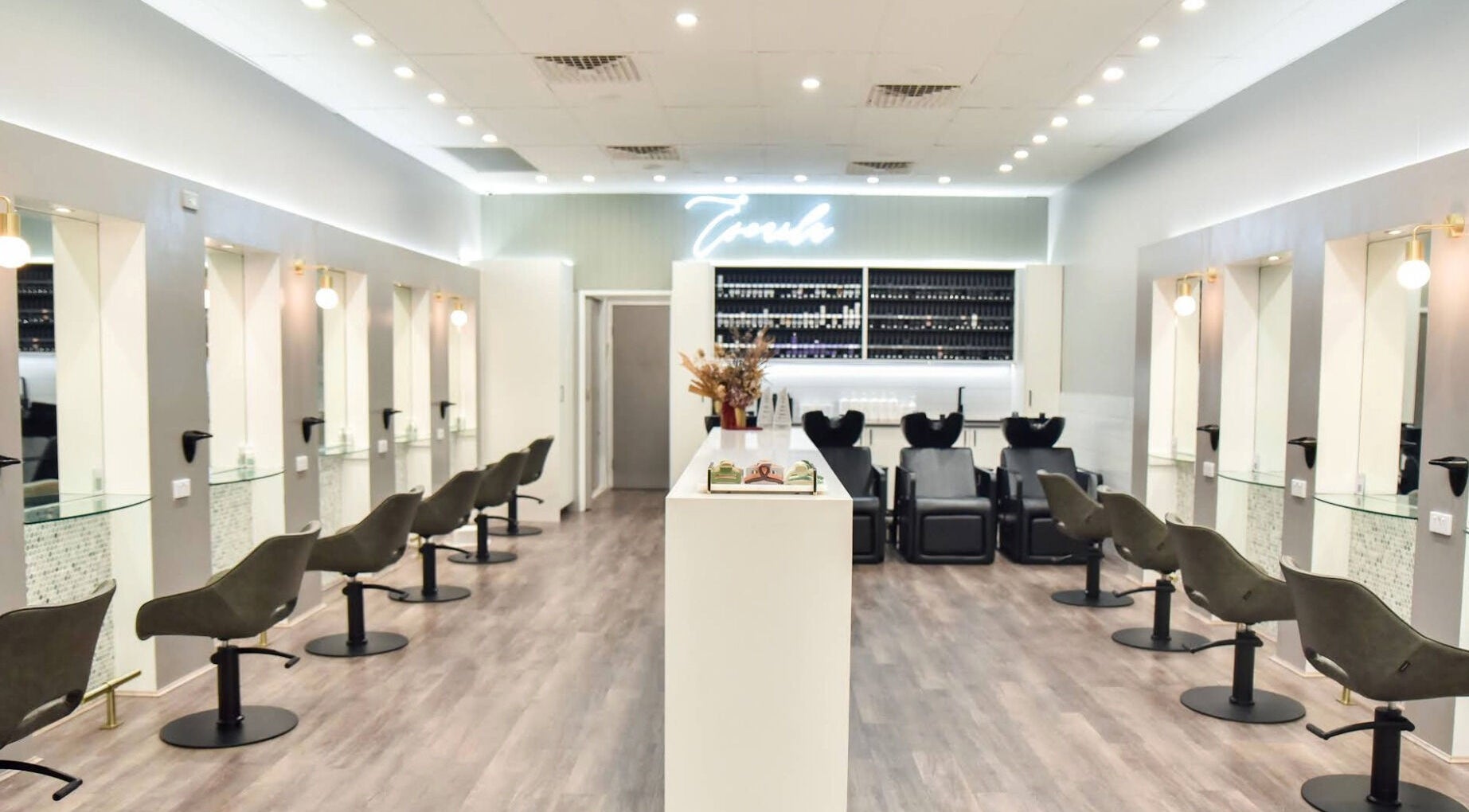 Modern interior of Escarla Hair salon in Narellan, New South Wales, AU, showcasing stylish chairs and sleek design.