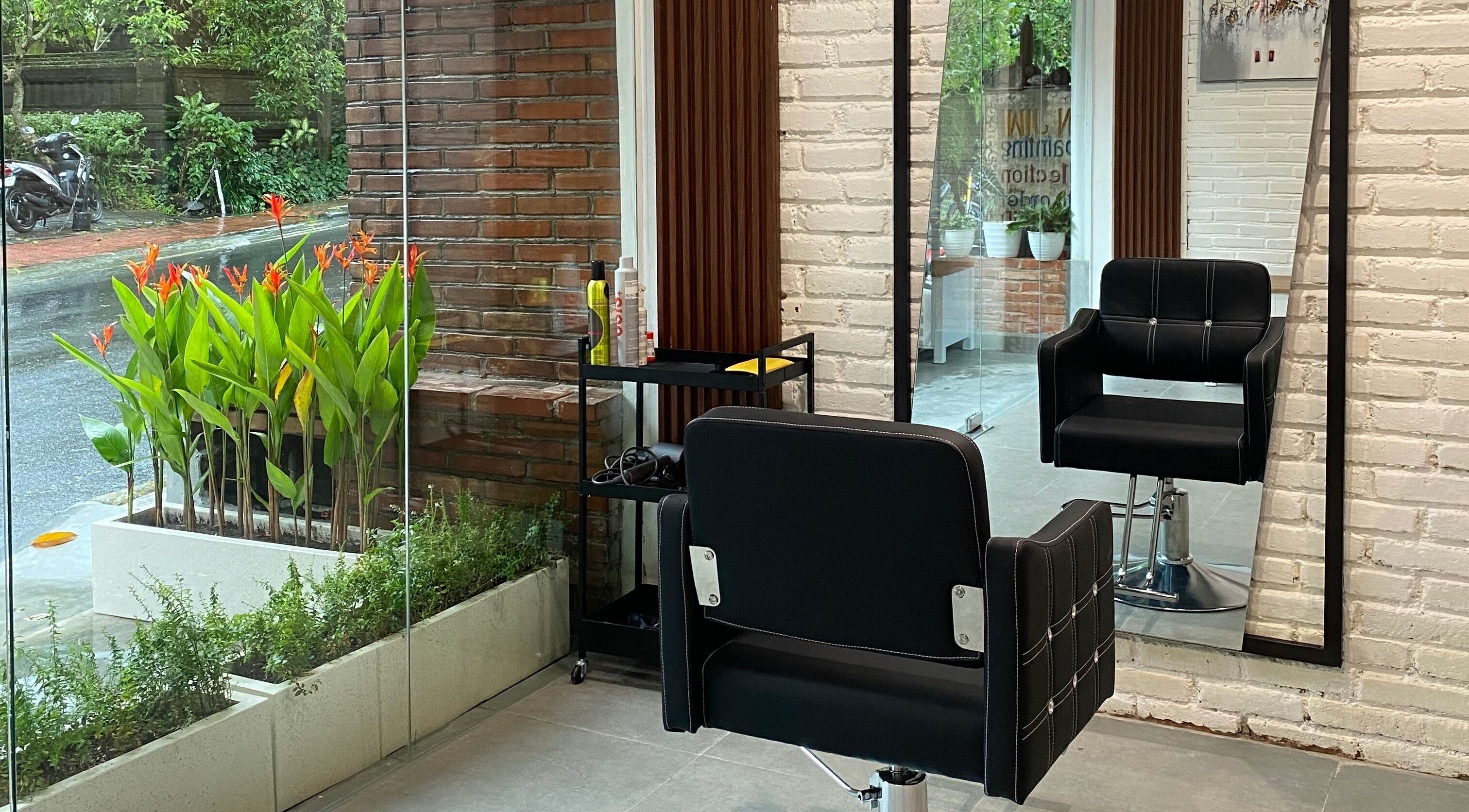 Modern chair and mirror at IXI Hair Beauty Salon Ubud, Bali, Bali, ID with lush greenery view.