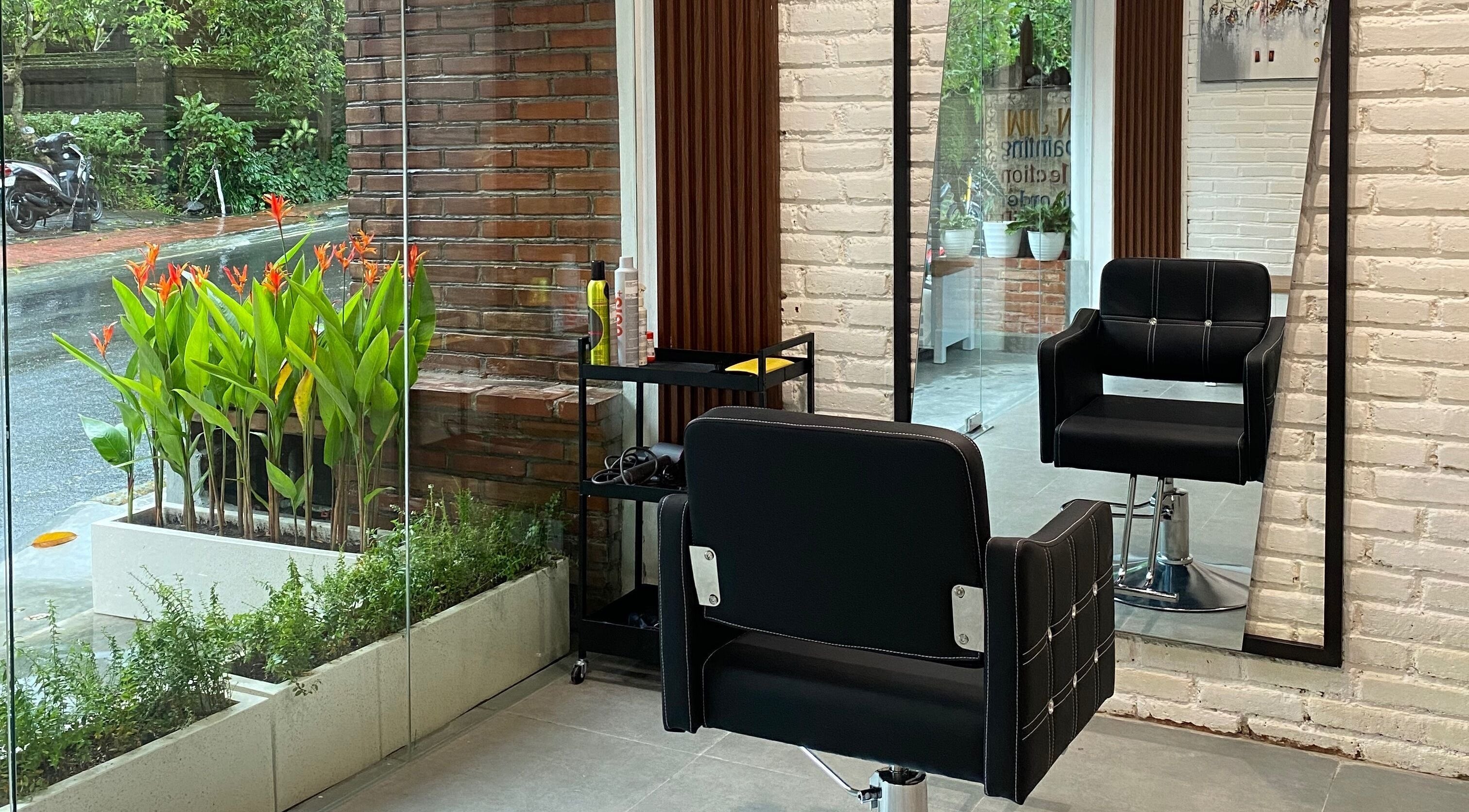 Modern chair and mirror at IXI Hair Beauty Salon Ubud, Bali, Bali, ID with lush greenery view.