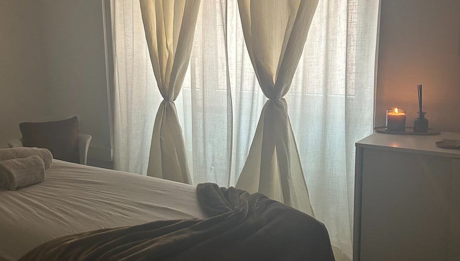 Calming treatment room at Terapeuta Vânia Custódio, Lisboa, Lisboa, PT with soft drapes and lit candle.