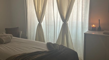 Calming treatment room at Terapeuta Vânia Custódio, Lisboa, Lisboa, PT with soft drapes and lit candle.