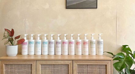 Hair care products on wooden shelf at Hue Hair and Beauty in Bristol, England, GB showcasing elegant salon vibes.