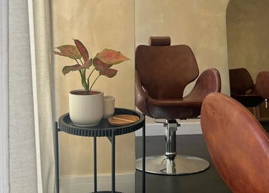 Luxurious salon chair at Hue Beauty, Bristol, England, GB, next to a stylish plant decor.