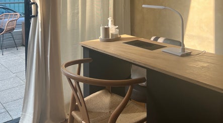 Cozy nail station at Hue Beauty, Bristol, England, GB, with elegant chair and ambient lighting.