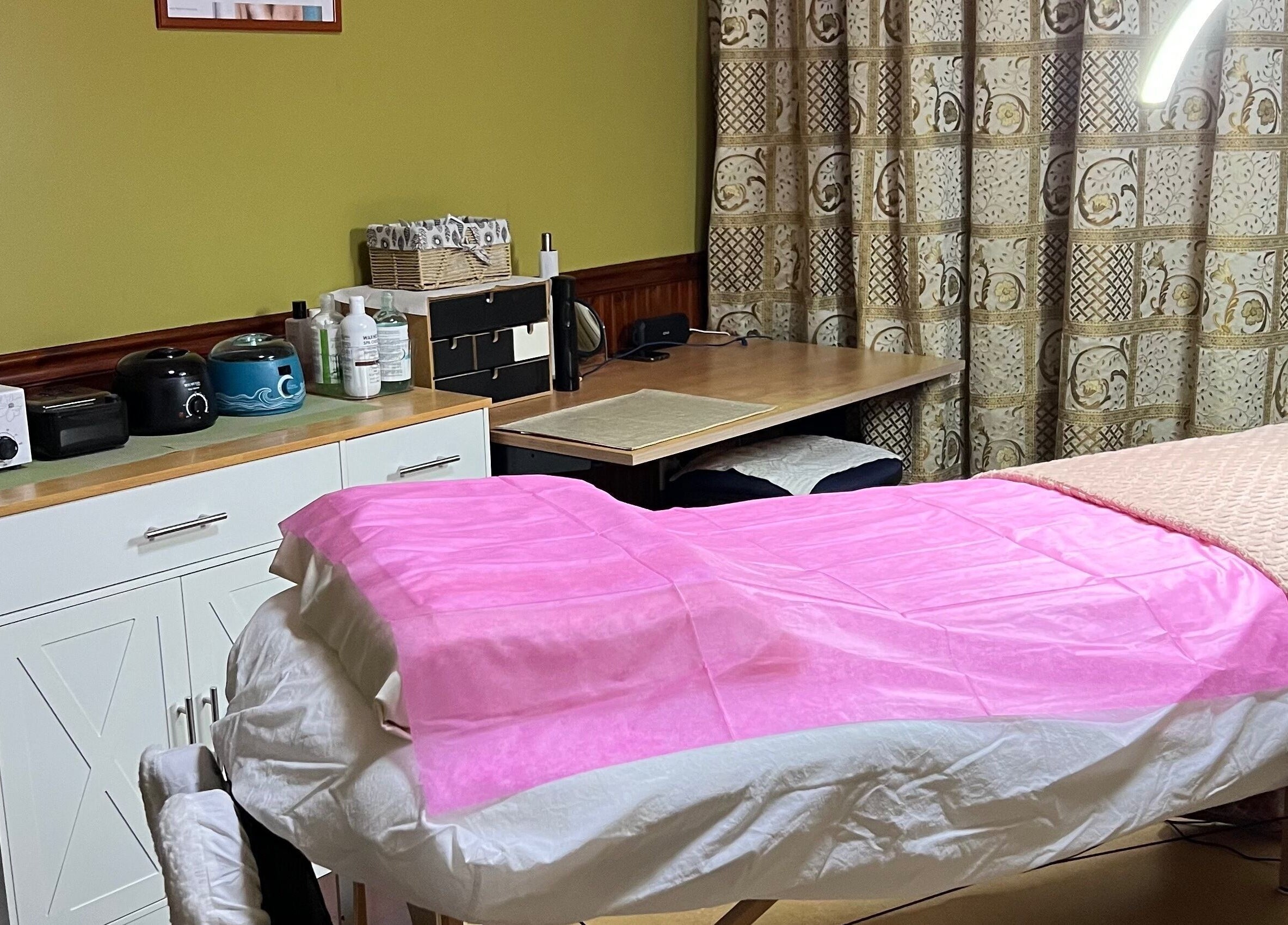Moderne behandelkamer bij Marilyn's Wax Bar in Paramaribo, Paramaribo, SR met roze bed en apparatuur.