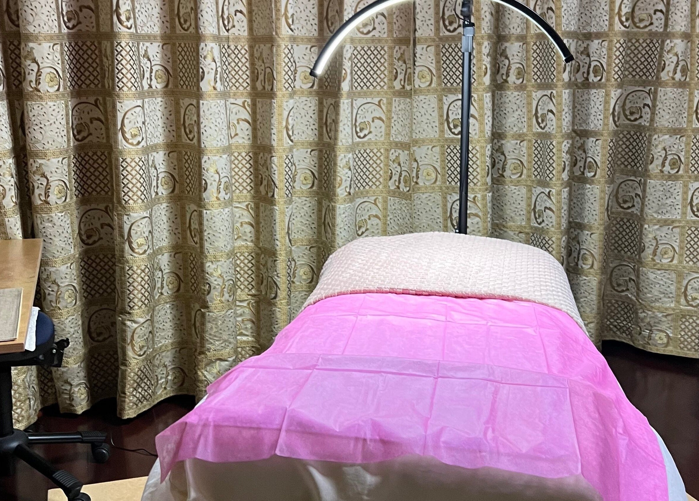 Rustige waxkamer bij Marilyn's Wax Bar in Paramaribo, Paramaribo, SR met roze bed en elegante inrichting.