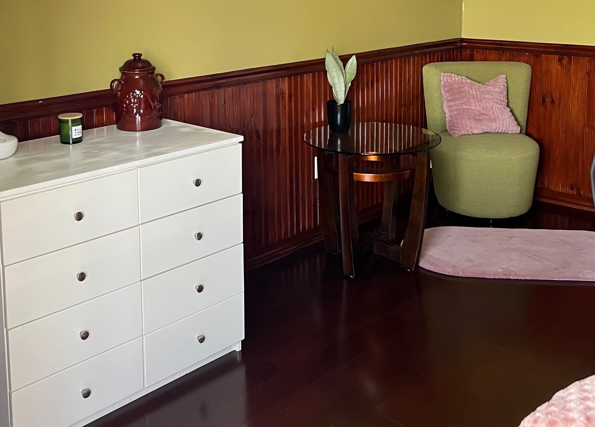 Gezellige wachtruimte bij Marilyn's Wax Bar in Paramaribo, Paramaribo, SR met groene stoel en kast.