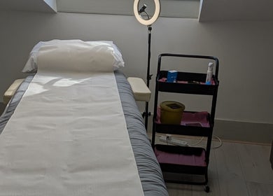 Serene treatment room at Elegant Touch Aesthetics, Southampton, England, GB, with bed and equipment cart.