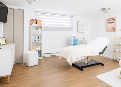 Salle de soin apaisante à Derma Peau Médico-Esthétique, Laval, Québec, CA, avec décor moderne et équipements de bien-être.