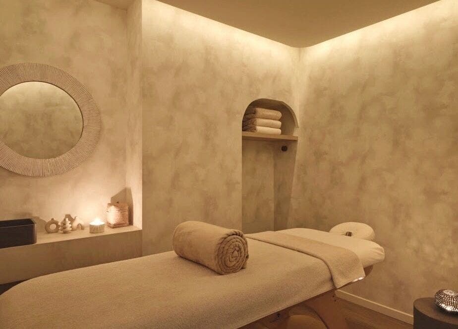 Salle de massage paisible chez Mon Regard Parfait, Paris, Île-de-France, FR, avec table et miroir élégant.