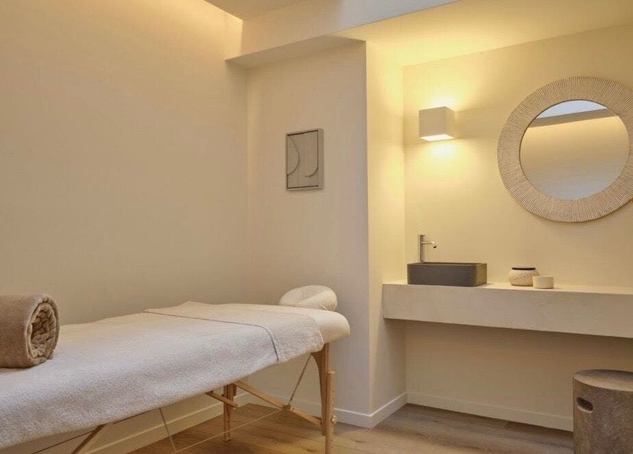 Salle de soins apaisante à Mon Regard Parfait, Paris, Île-de-France, FR avec table de massage élégante.