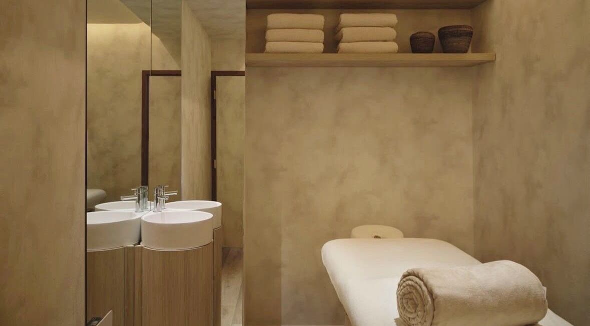 Salle de massage élégante chez Mon Regard Parfait à Paris, Île-de-france, FR, avec lit et serviettes pliées.