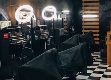 Interior of Gunting karat Barbershop(Hannan) in Banting, Selangor, MY, showing stylish barber stations with bright lighting.