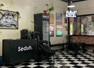 Interior of Gunting karat Barbershop(Hannan), Banting, Selangor, MY with checkered flooring and unique decor.