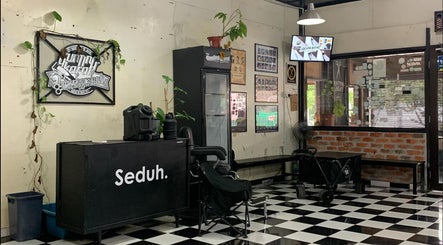 Interior of Gunting karat Barbershop(Hannan), Banting, Selangor, MY with checkered flooring and unique decor.