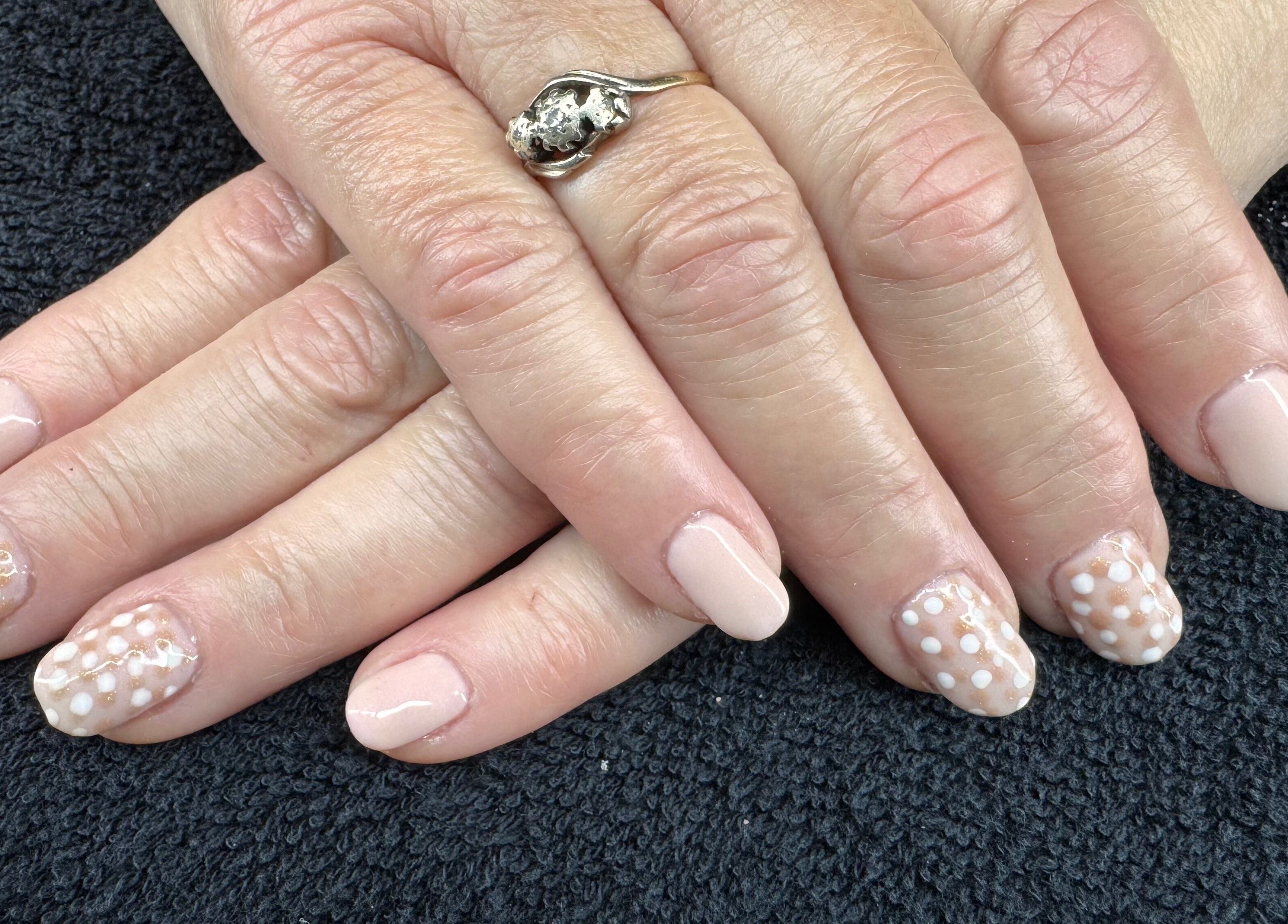 Polka dot nail design at The Rose Collection, Weston-super-mare, England, GB on manicured hands.