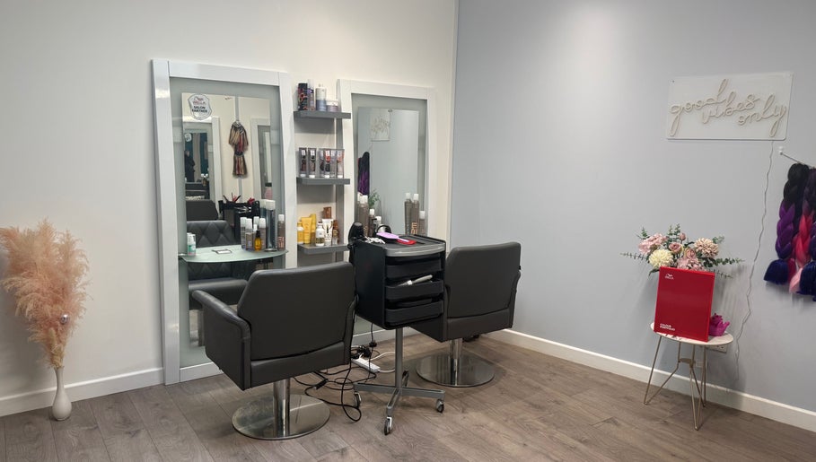 Modern salon interior at Hair by Jodie, Kilmarnock, Scotland, GB, featuring styling chairs and beauty products.