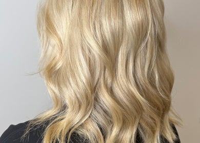 Blonde wavy hairstyle at Hair by Jodie, Kilmarnock, Scotland, GB showcasing soft curls and shine.