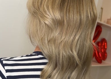 Blonde wavy hairstyle at Hair by Jodie in Kilmarnock, Scotland, GB. Modern haircut with soft curls.