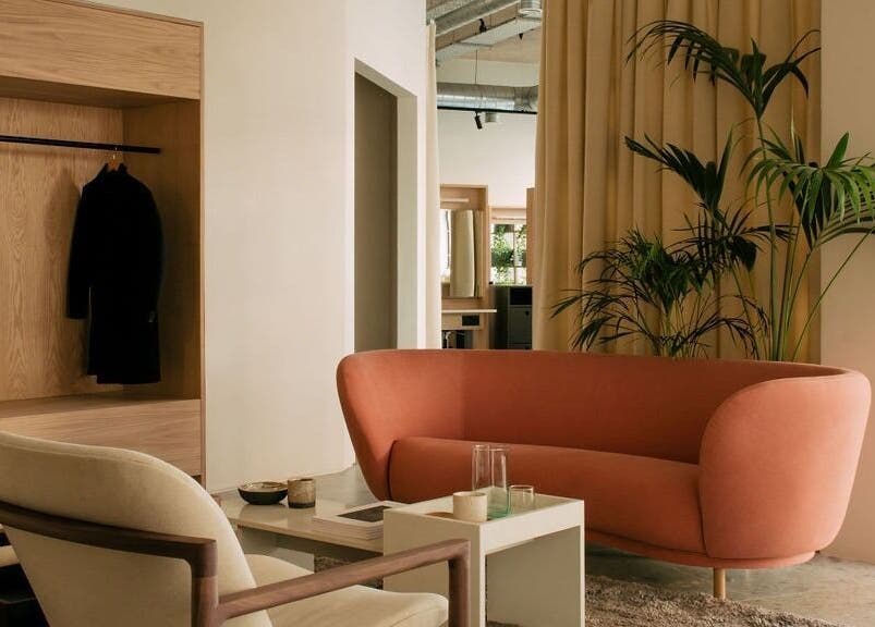 Relaxing seating area at Glasshouse Salon in London, England, GB with modern furniture and lush greenery.
