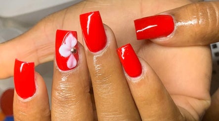 Red nails with pink floral design at Banusti Beauty Nails in Burlington, Massachusetts, US.