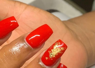 Bright red nails with gold leaf design at Banusti Beauty Nails, Burlington, Massachusetts, US.