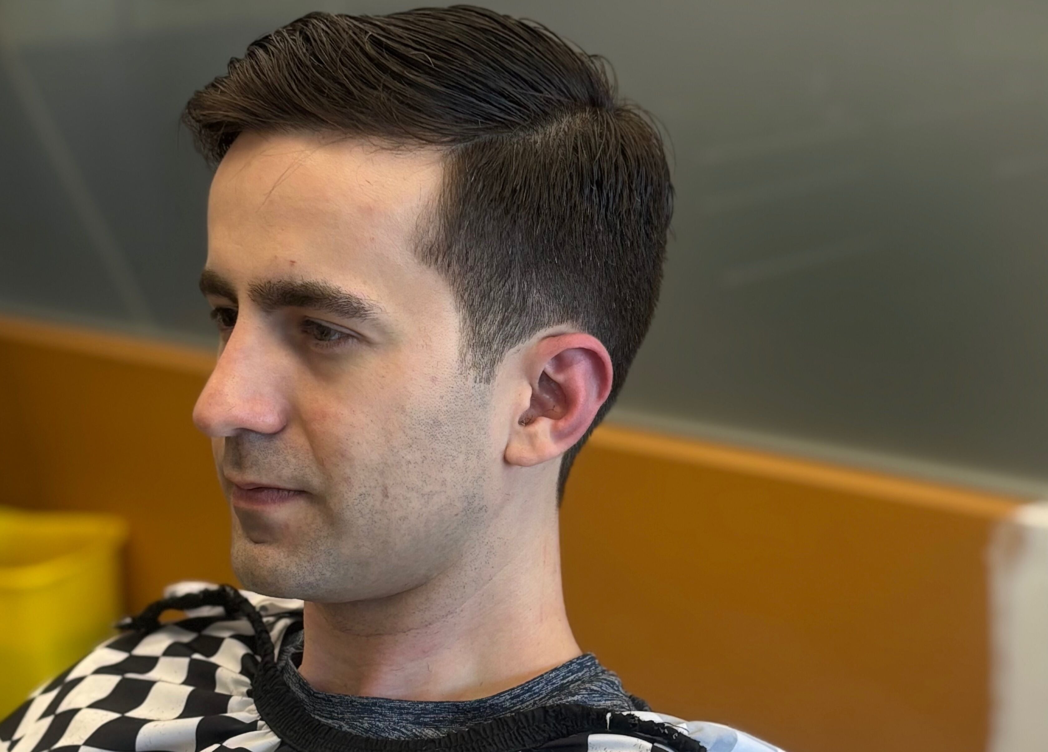 Side profile of a man with a stylish haircut at Mankind Barbershop in Calgary, Alberta, CA.