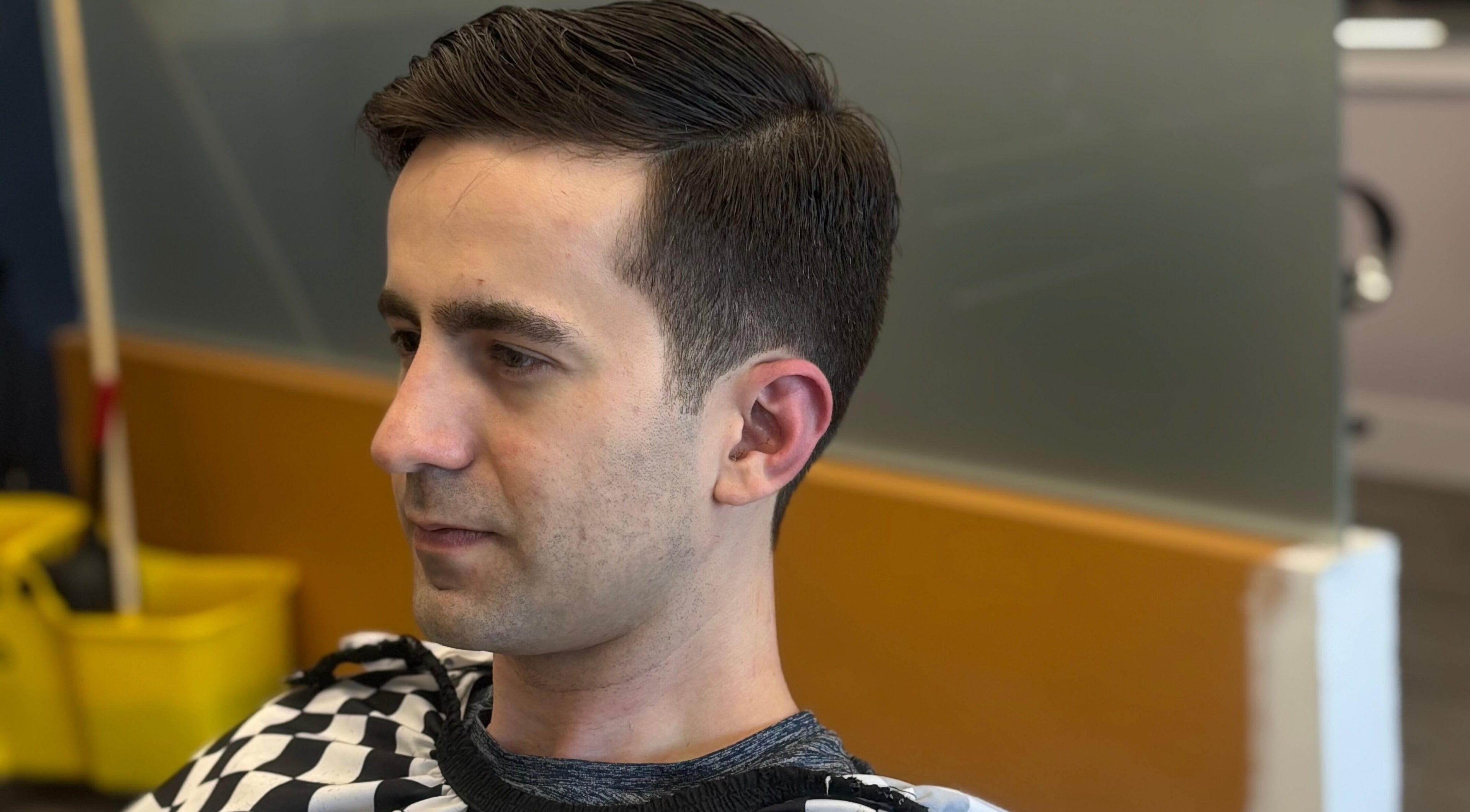 Side profile of a man with a stylish haircut at Mankind Barbershop in Calgary, Alberta, CA.