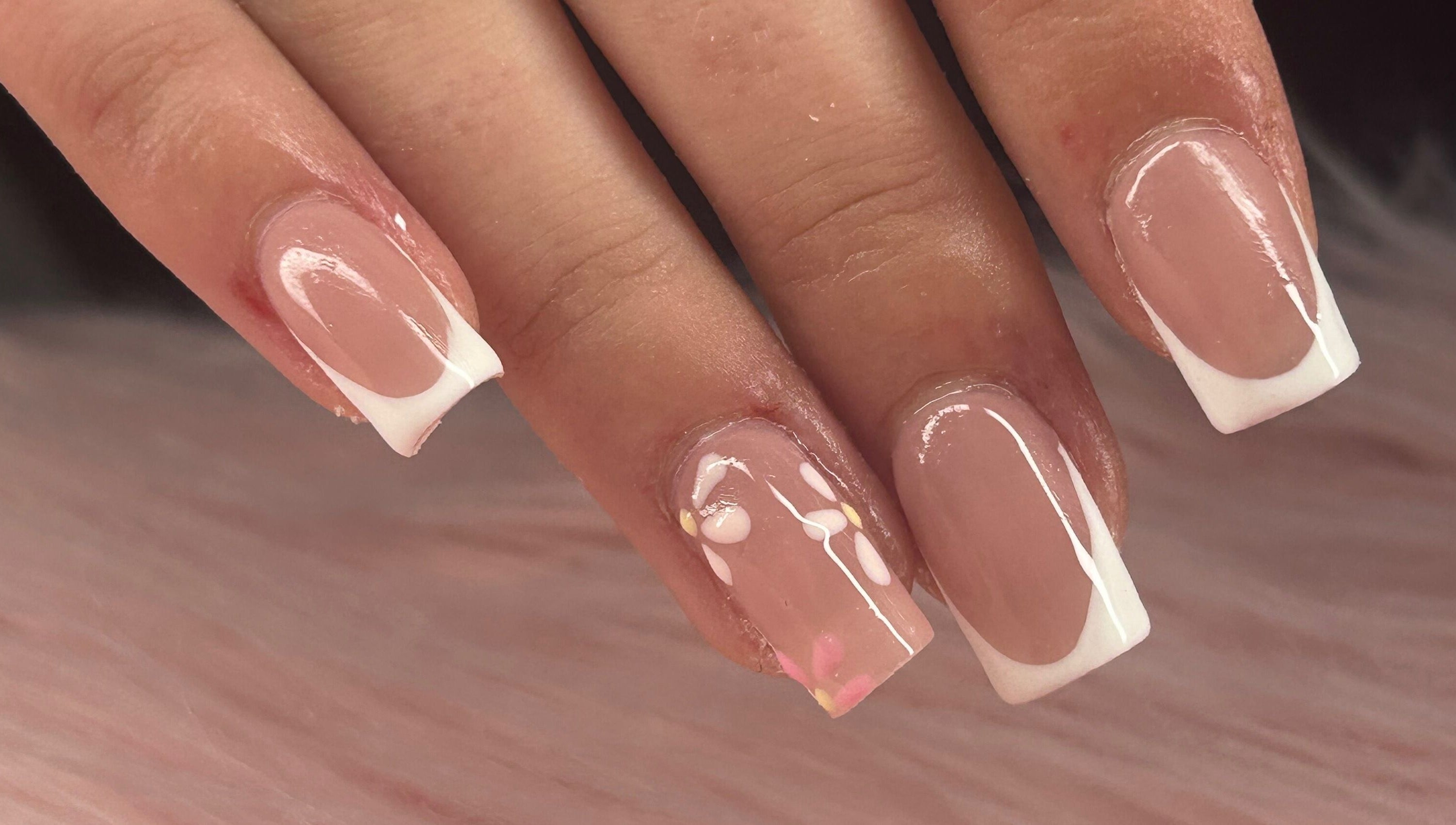 Close-up of French tip nails with delicate floral design at arushisnails, Crawley, England, GB.