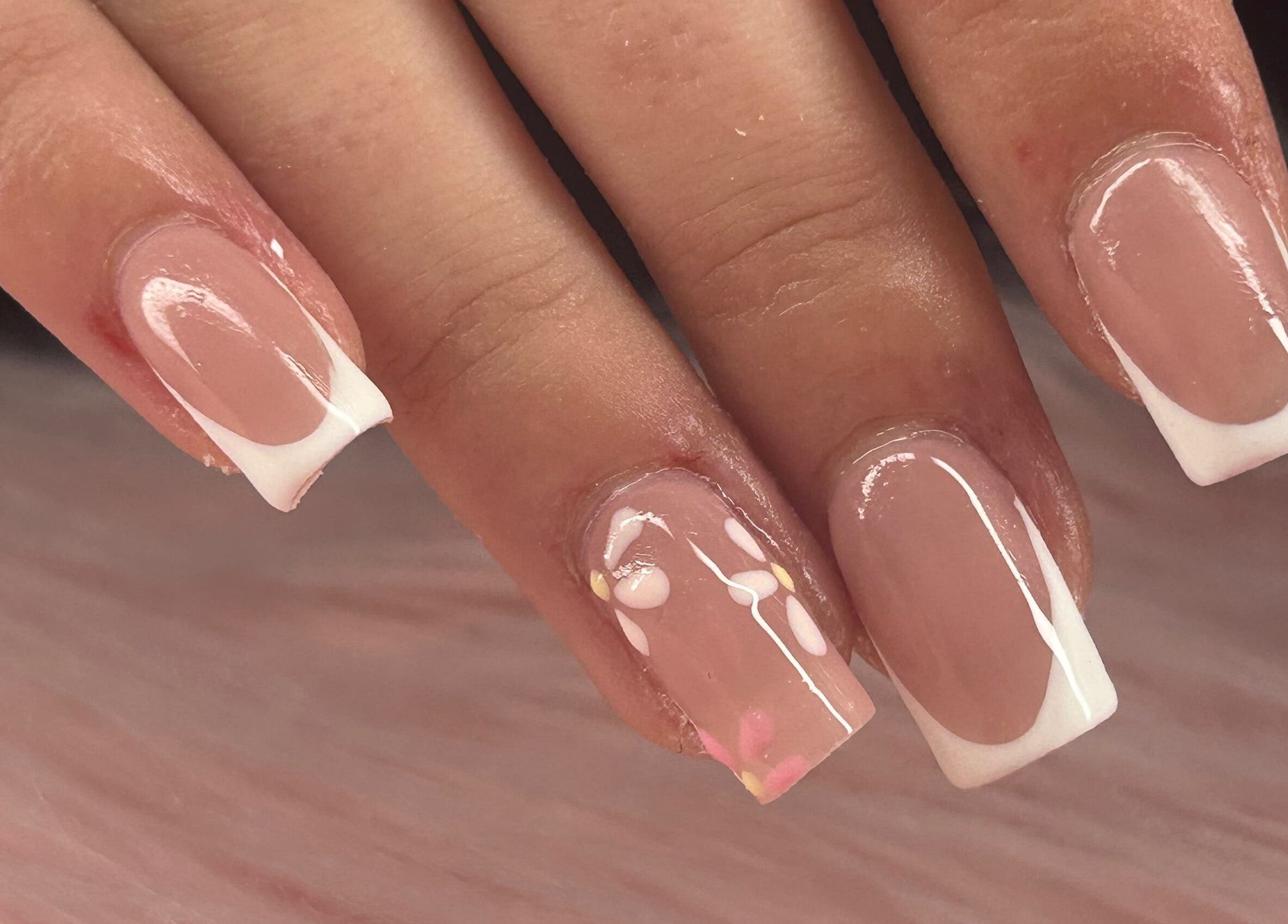 Close-up of French tip nails with delicate floral design at arushisnails, Crawley, England, GB.