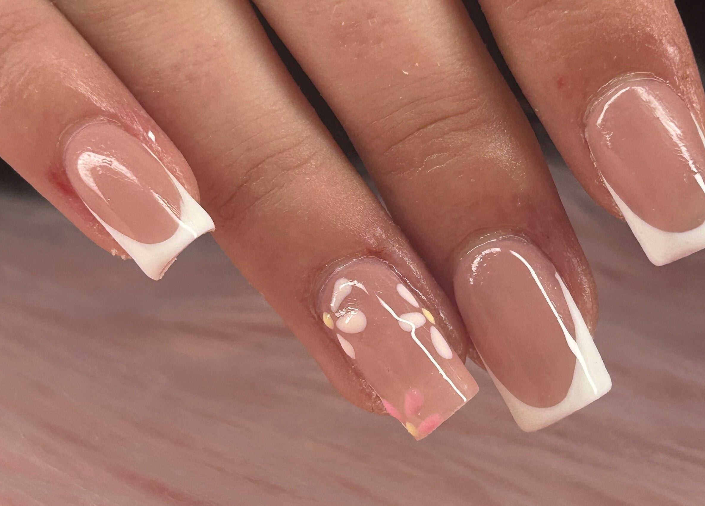 Close-up of French tip nails with delicate floral design at arushisnails, Crawley, England, GB.