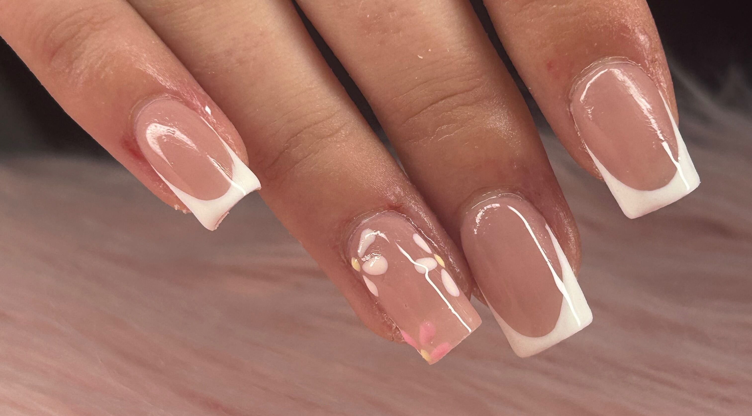 Close-up of French tip nails with delicate floral design at arushisnails, Crawley, England, GB.