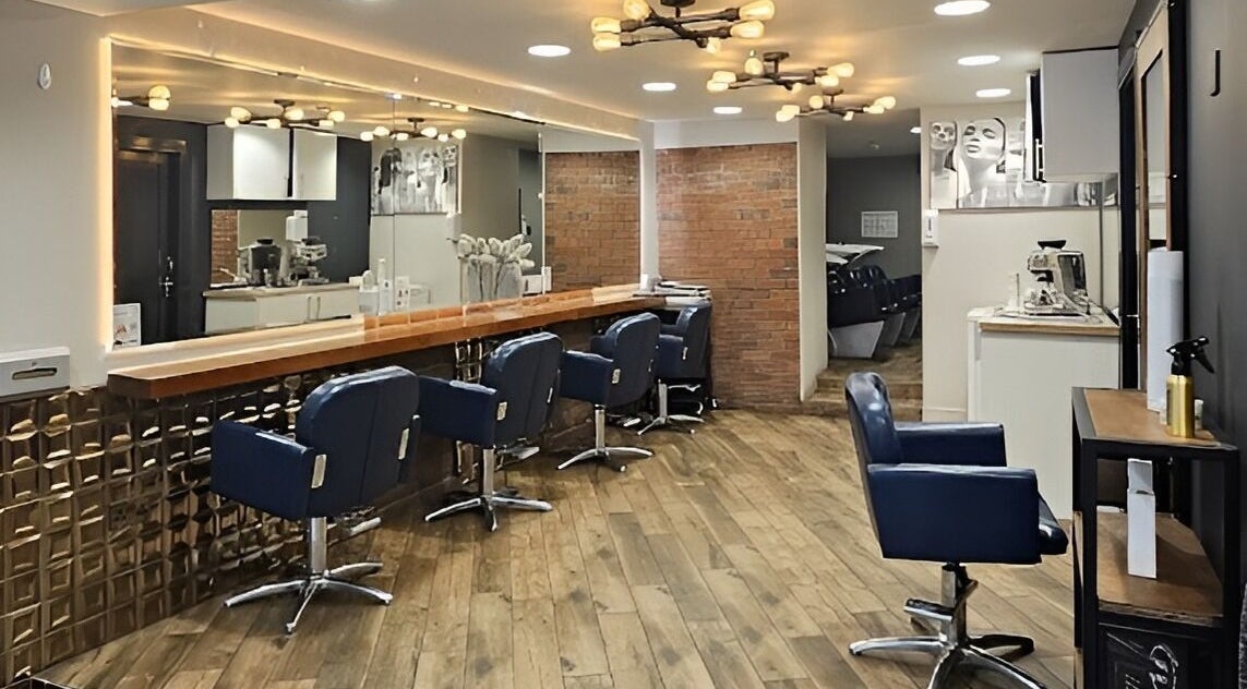 Modern interior of Sleek Hair Salon&Nail Bar in Dublin 7, County Dublin, IE with stylish blue chairs and warm lighting.