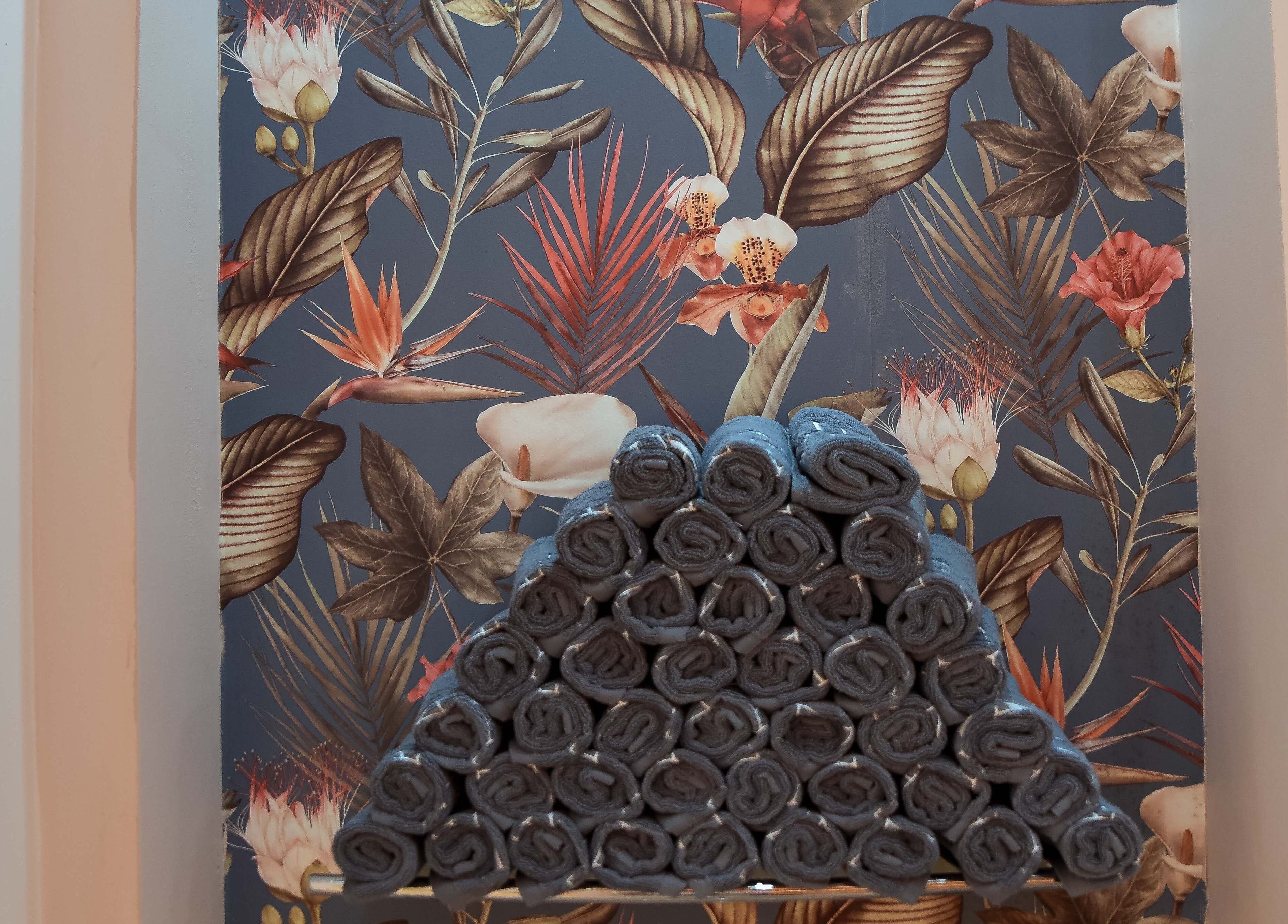 Rolled towels at Beauchamp Nails Bar, against floral wallpaper in London, England, GB.