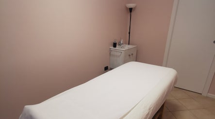Sala massaggi a Sinfonia Estetica, Montichiari, Lombardia, IT con lettino bianco e lavabo.